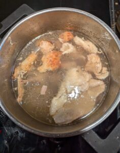 The collected chicken bones and scraps simmering in the pot