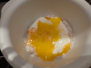 The bowl with flour/oat mixture, and a pool of buttermilk, beaten egg, and melted butter on top.