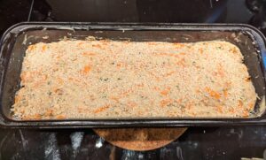 Dough in the pan, topped rather heavily with sesame seeds