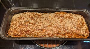 A pan of fresh baked bread sitting on a cooling rack, immediately after coming out of the oven