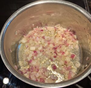 A pan with translucent sautéed onions and garlic.