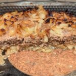 Half a baking dish of the casserole, showing the cut cross-section