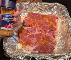 The baking dish, now with seasoned meat on top of the onions and garlic.