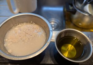 Measuring cups with yeast water and olive oil