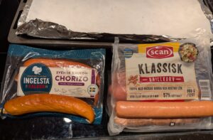 Two packs of sausages side by side, with one sausage sitting on top of each for a better view