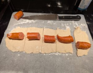 Sausage pieces lying on the dough strips