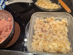 Cooked cabbage layer on top of a layered casserole in a Pyrex baking dish