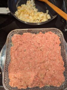 The same Pyrex baking dish with the meatloaf mixture layered in