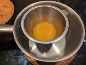 Stainless steel measuring cup with pan juices