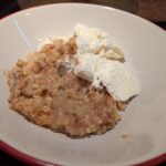 A bowl of apple crumble with ice cream
