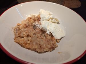 A bowl of apple crumble with ice cream