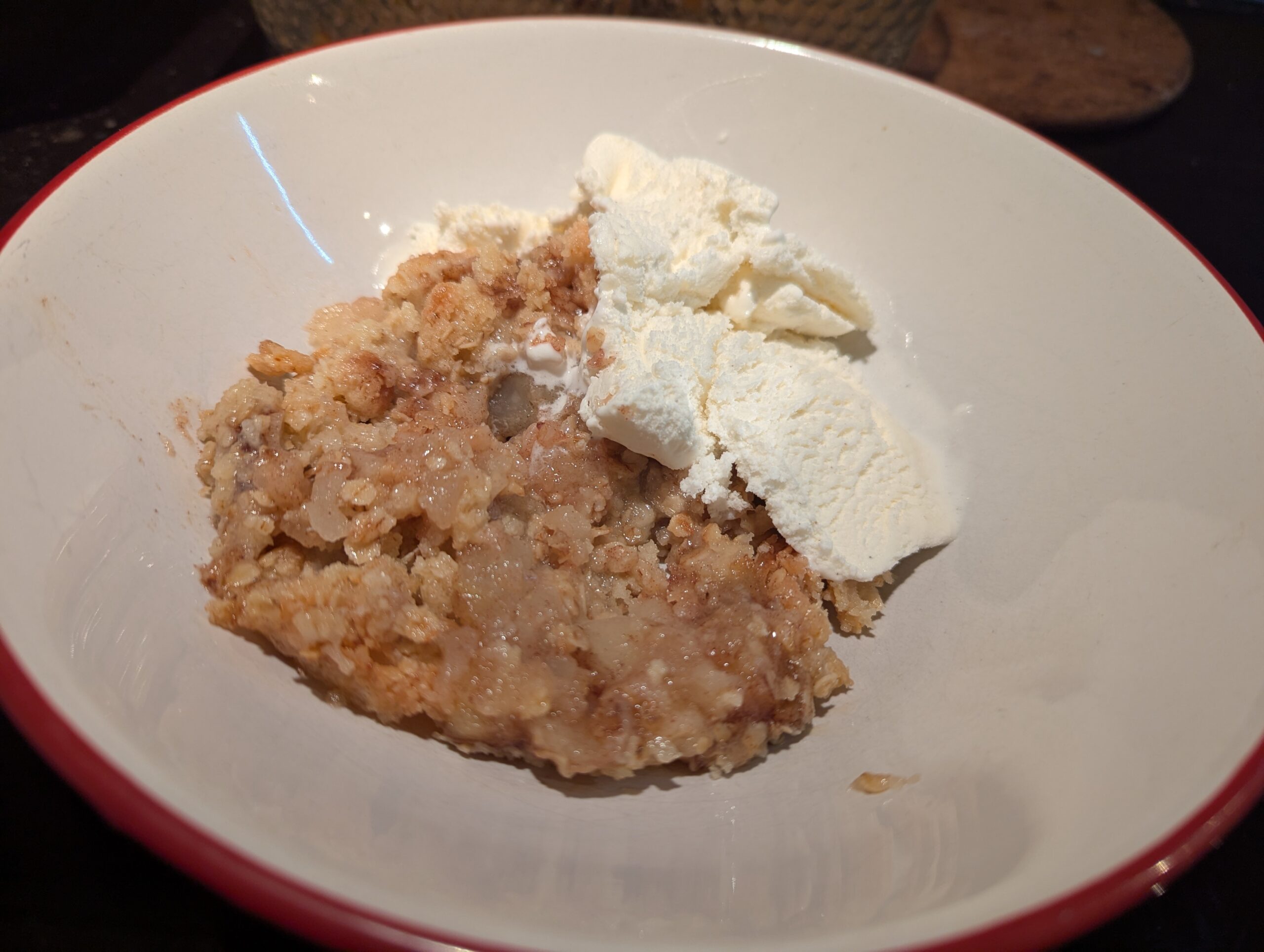 A bowl of apple crumble with ice cream