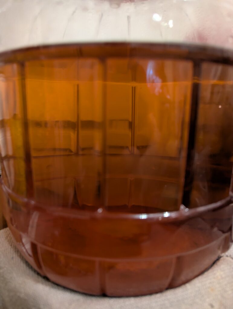 Finished strawberry watermelon wine in a fermenting jar
