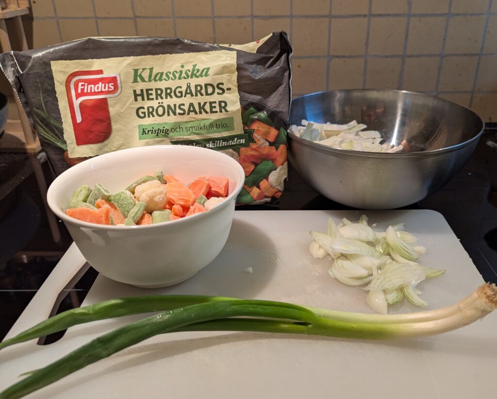 Cut cabbage, chunky frozen vegetables, a small sliced onion, and a large green onion