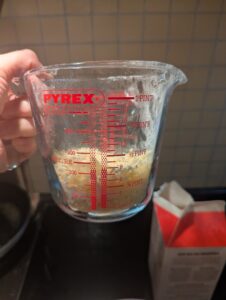 Grated cheese in a Pyrex measuring cup
