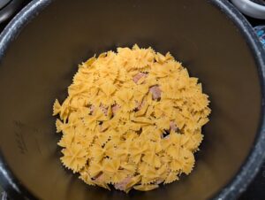 Layer of dry pasta on top of the meatballs