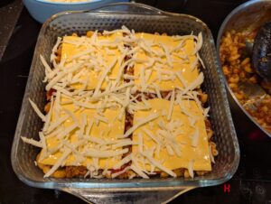 Cheese distributed on top of the first layer of macaroni.
