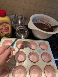Getting ready to fill the lined cupcake cups with batter, using a small metal ladle