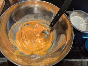 Sludgy peanut butter and butter mixture in a steel bowl