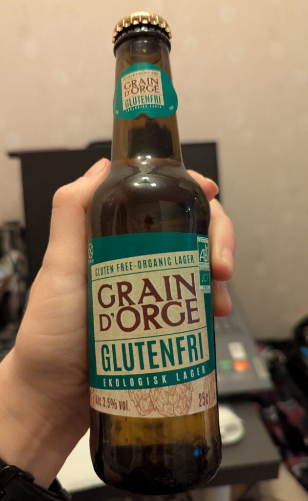 A hand holding a bottle of Grain D'Orge 3.5% ABV gluten free lager