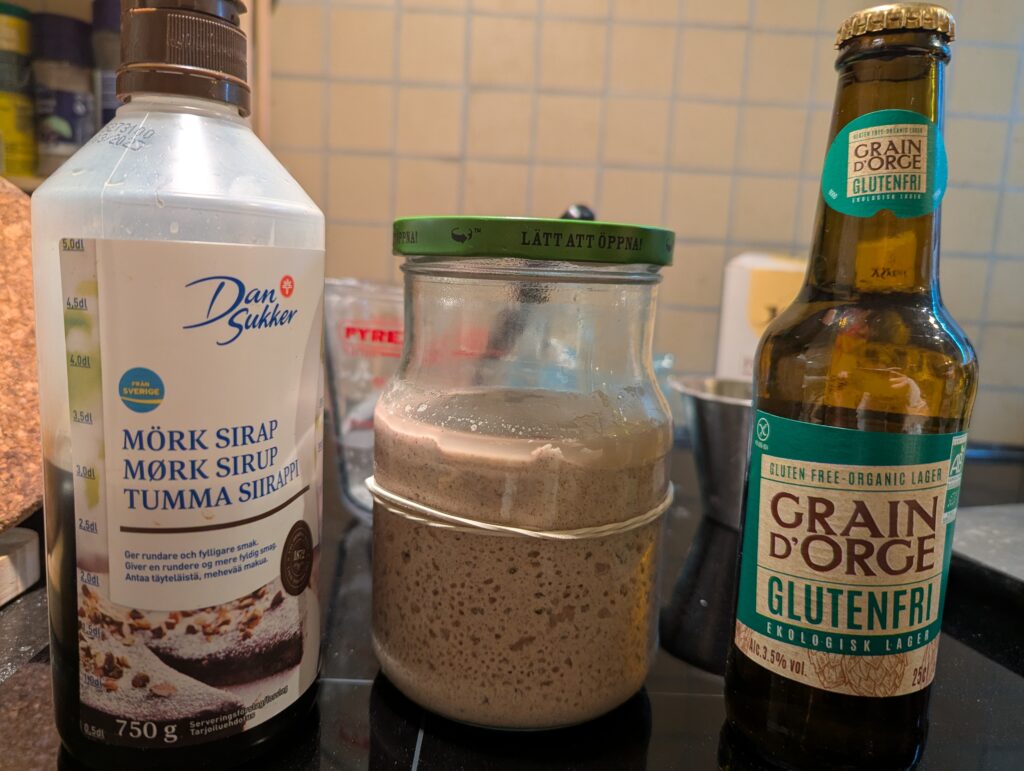 Dark syrup, a jar of bubbling yeast starter, and the bottle of beer