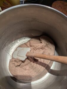 Dough being pulled away from the bowl with a rubber spatula